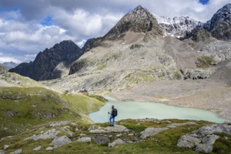 Hiker on the way to the Adolf Nossberger Hut, view of the turquoise-blue mountain lake Großer