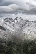 View of steep, rocky mountain landscape with fresh snow in summer, on the Vienna High Trail,