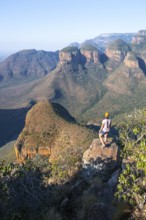 Hiker at Blyde River Canyon with Three Rondawels peak, view of canyon with Blyde River and Table