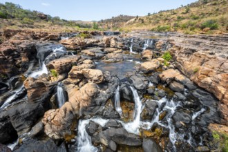 Waterfall on orange-coloured rock cliffs, long exposure, Blyde River, Bourke's Luck Potholes,