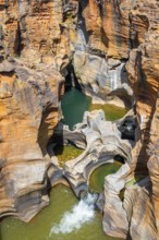 Eroded rock formations, canyon with steep orange-coloured rock cliffs with the Blyde River,