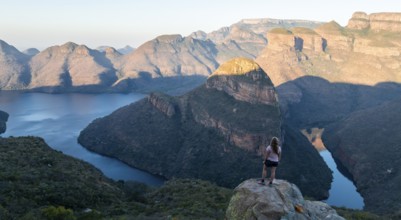 Hiker enjoying panorama, sunset at Blyde River Canyon with Three Rondawels peak, view of canyon