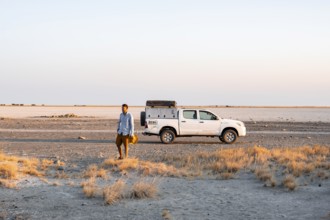 Tourist with off-road car exploring dry landscape, Kubu Island (Lekubu), Sowa Pan, Makgadikgadi