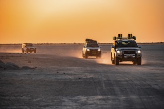 Tourists explore dry landscape by off-road car, Kubu Island (Lekubu), Sowa Pan, Makgadikgadi salt