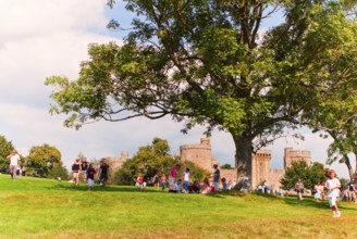 Tourists and locals in front of Bodiam Castle, located in East Sussex near the River Rother. It has