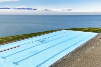 View from above of infinity pool by the sea, thermal bath, heated outdoor pool in Hofsos by