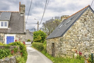 Alley in an old French village with old stone houses with flowers in bloom in the countryside a