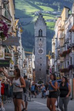 Tourists in the old town, colourful houses in the main street, Zwölferturm tower at the back,