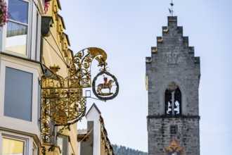 Artistic golden hanging sign, nose sign, old town centre, behind Zwölferturm, Sterzing, South