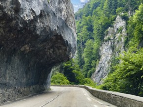 Mountain road in the Western Alps in the style of a balcony road with rock overhang above the
