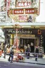 Chinese New Year decorations being placed on Mandarin Jewellery shop building, Hong Kong, Asia 1964