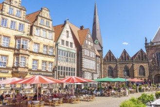 Historic row of buildings with bay windows, gabled houses, pointed tower and nave of Our Lady's