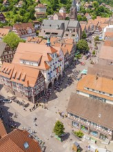 Aerial view of a half-timbered town with church and market square during a busy summer day, 950