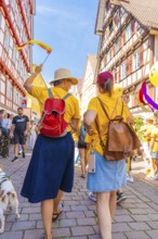 Two woman with hats in a busy, festive street, 950 years Calw, parade Calw, Black Forest, Germany