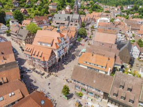 Aerial view of a colourful half-timbered town with a lively market square and church on a summer's