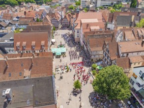 Aerial view of a historic town centre with an event and traditional architecture, 950 years of