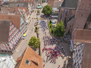 Lively town centre with people at an event, surrounded by half-timbered architecture, 950 years