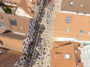 Aerial view of a busy alley with decorative colourful balloons and many people, 950 years Calw,
