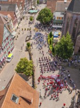 Large crowd at a street festival, surrounded by half-timbered architecture and summer weather, 950