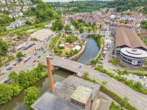 Aerial view of a town in rural surroundings with river, bridge and dominant buildings, 950 years of