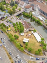 Aerial view of a town with river, Ferris wheel and fairground in summer, 950 years Calw, parade