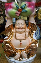 Buddah figure in a shop window, China Town, New York City, USA