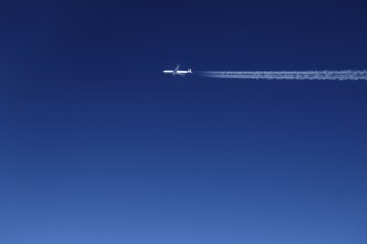 View of a passing aircraft in the blue sky at an altitude of 10, 000 metres, Atlantic flight to New