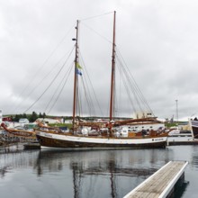 Sailing boat in the harbour, fishing village at Skjalfandi Bay, rain clouds, Husavik, Húsavík,