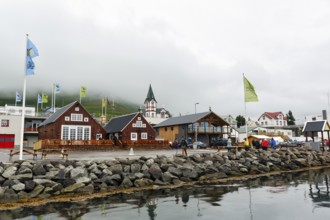 Old wooden houses with church, fishing village at Skjalfandi Bay, rain clouds, Husavik, Húsavík,