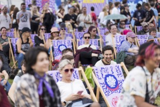 Festivalgoers on deckchairs have fun at the LGBTQTIES comedy in the Fashion Palooza at the