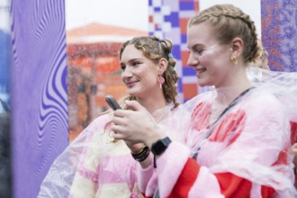 Festival visitors Emily and Celine from Halle take photos of themselves at Fashionpalooza at the