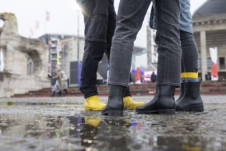 Festival visitors with rubber boots in front of the Olympic Stadium at the Lollapalooza Festival in