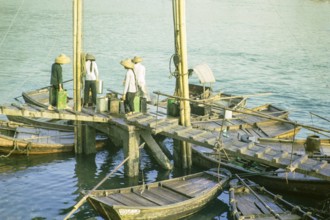 Boat dwellers with cans of water on jetty in the harbour at Aberdeen, Hong Kong, Asia 1964
