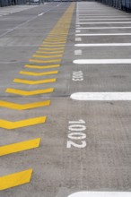 Markings on a car park deck, Direction of travel marking, Numbered parking spaces, Graphic