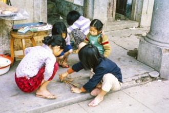 Children playing spillikins on street, Tai Po, New Territories, Hong Kong, Asia, 1964
