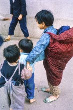 NB Poor focus. Child carrying baby looking after young children, Tai Po, New Territories, Hong