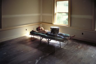 Young man lying on a couch with his drums, New Jersey, USA