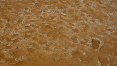 Close-up of ochre-coloured soil depicting natural patterns and textures, salt lake, Tigaki, nature