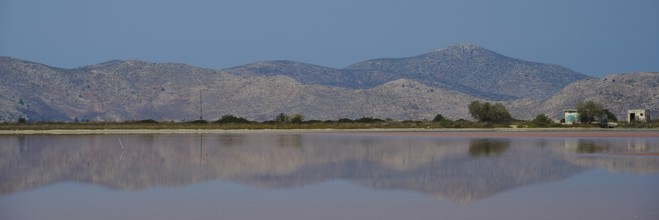 Clear mountains with a calm lake in the foreground, soft reflections and blue sky, salt lake,
