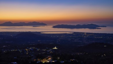Sweeping panoramic view of coastal landscape at sunset, shadows and city lights visible, salt lake,