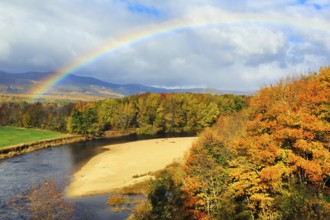 Scenic river landscape with rainbow, Saco River in Mount Washington Valley, colorful fall leaves,