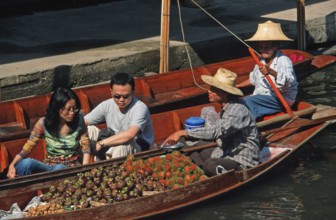 Retailers and customers in their boats at the Damnoen Saduak floating market, Thailand, December