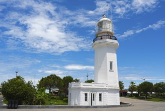 White lighthouse against a cloudy sky surrounded by palm trees and a road, lighthouse, Batumi,