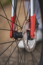 Close-up of a bicycle part with red and silver design showing the mechanics and brake disc,