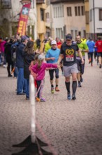 Runners clap off with spectators on a paved road, Triathlon, Calw, Germany