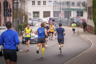 Runners moving on a street, residential building in the background, triathlon, Calw, Germany