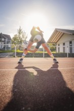 Runner stretching on a running track in sunshine, Triathlon, Calw, Germany