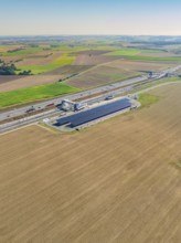 Solar system next to a motorway, surrounded by agricultural land, e-charging park, Merklingen,