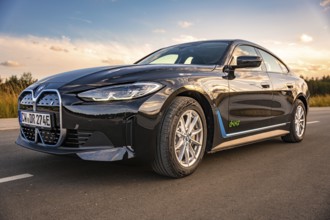 Shiny black car on a road with blue sky in the background, BMW i7 electric car, Deer e-Carsharing,