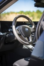 View of the modern steering wheel and display in the interior of a car, BMW i7 electric car, Deer
